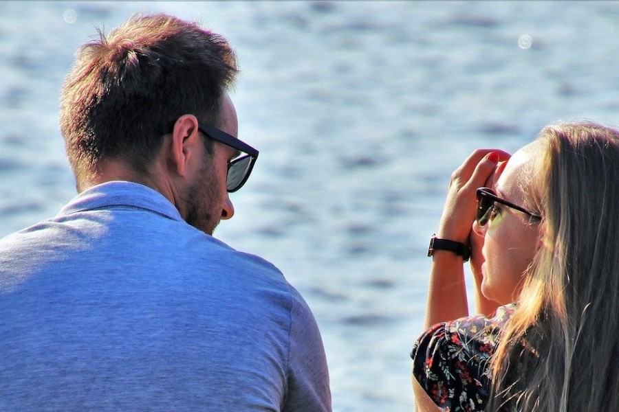 Man en vrouw met elkaar in gesprek bij water